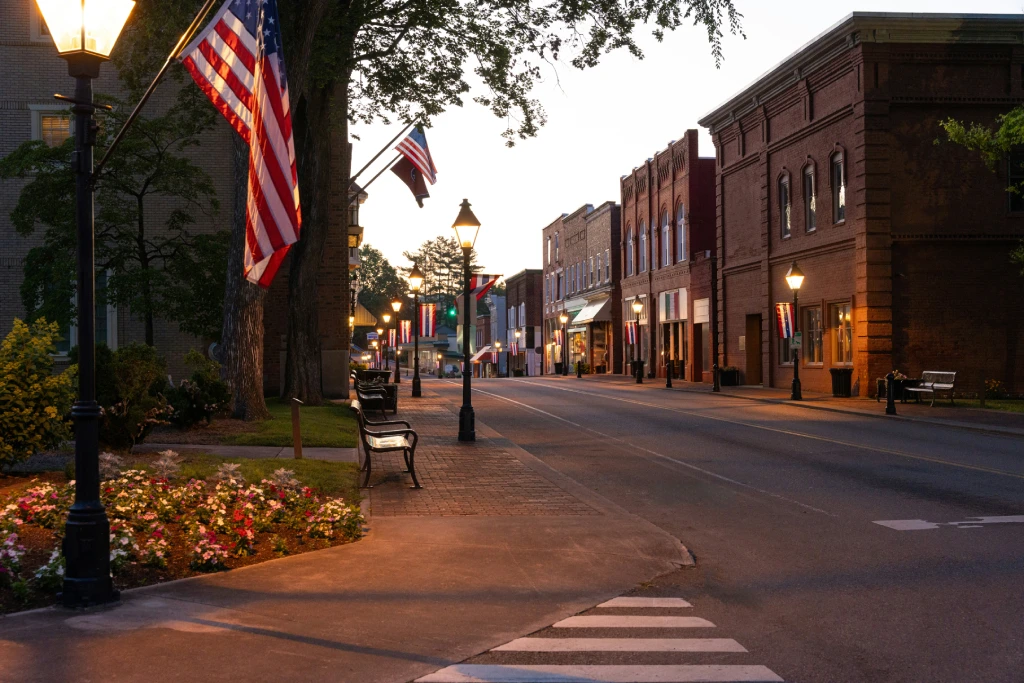Historic Main Street Downtown at Dusk with American Flags Brick Buildings and Lamp Posts.jpg