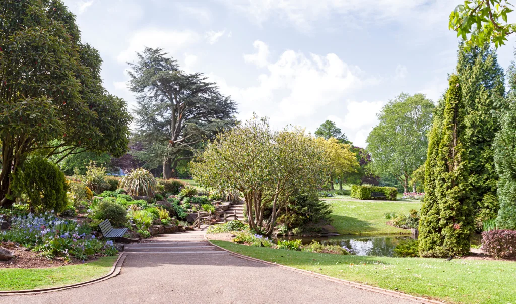 Public Park Botanical Garden with Paved Walking Path Pond and Stone Steps.jpg
